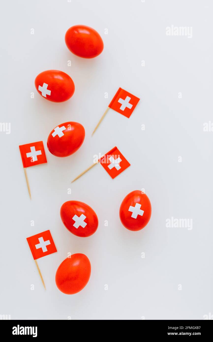 Festeggiamenti per la festa nazionale svizzera il 1 agosto con le uova  tradizionali colorate come la bandiera svizzera. Uova rosse e bandiere  svizzere sparse intorno Foto stock - Alamy