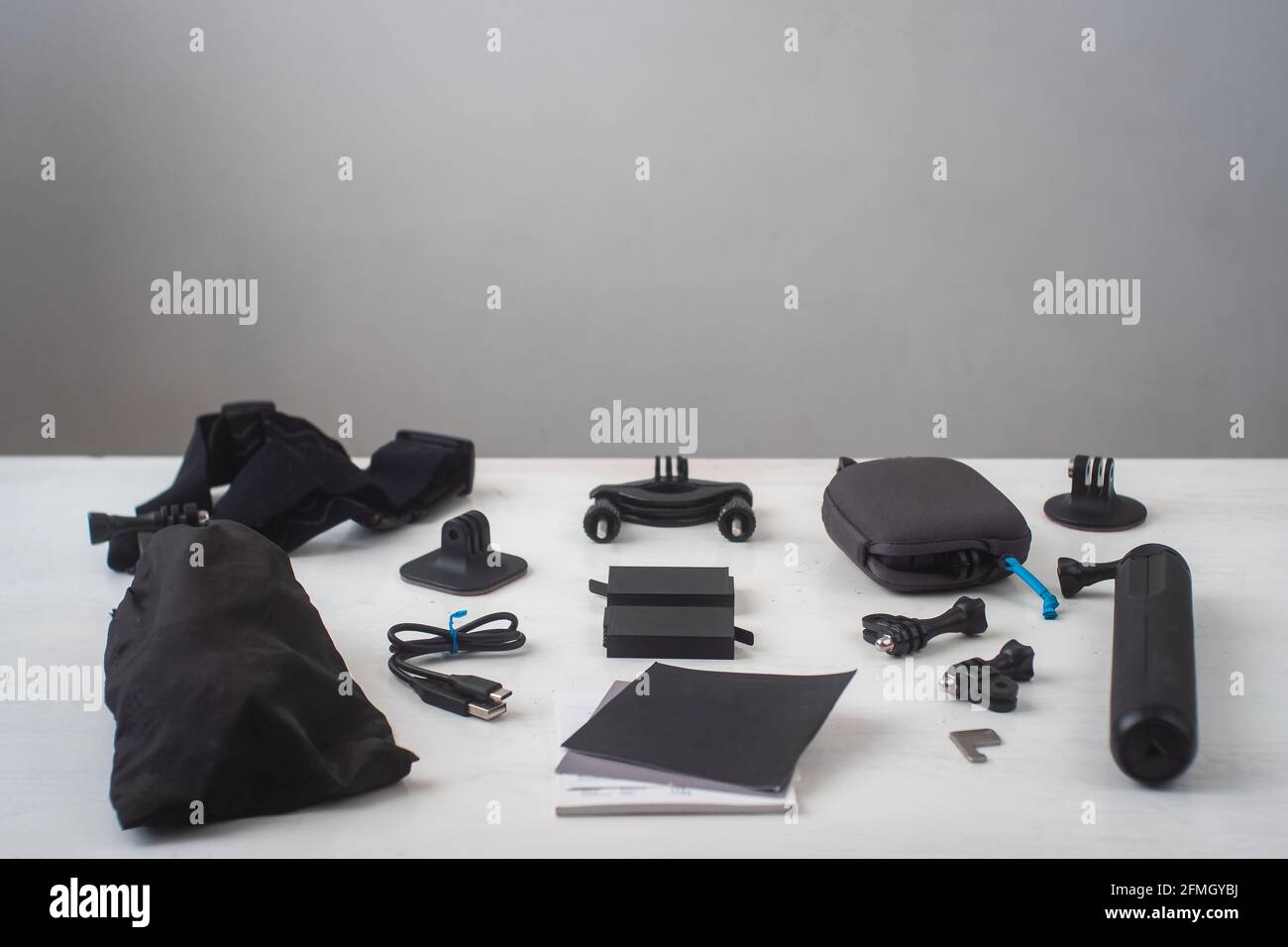 360 fotocamera con tutti i suoi accessori su un tavolo bianco Su sfondo grigio Foto Stock