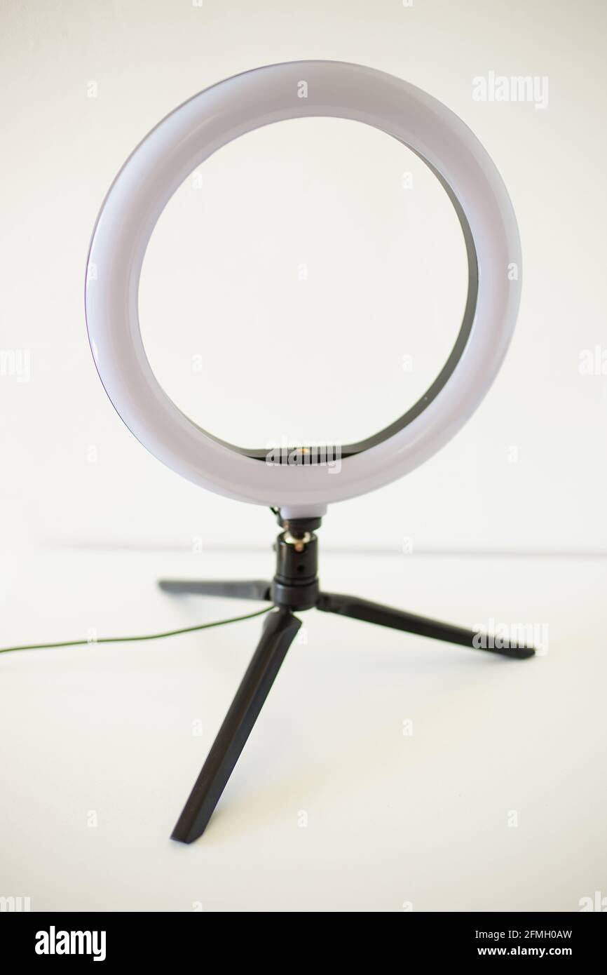 Lampada ad anello su treppiede su tavolo bianco. Foto Stock