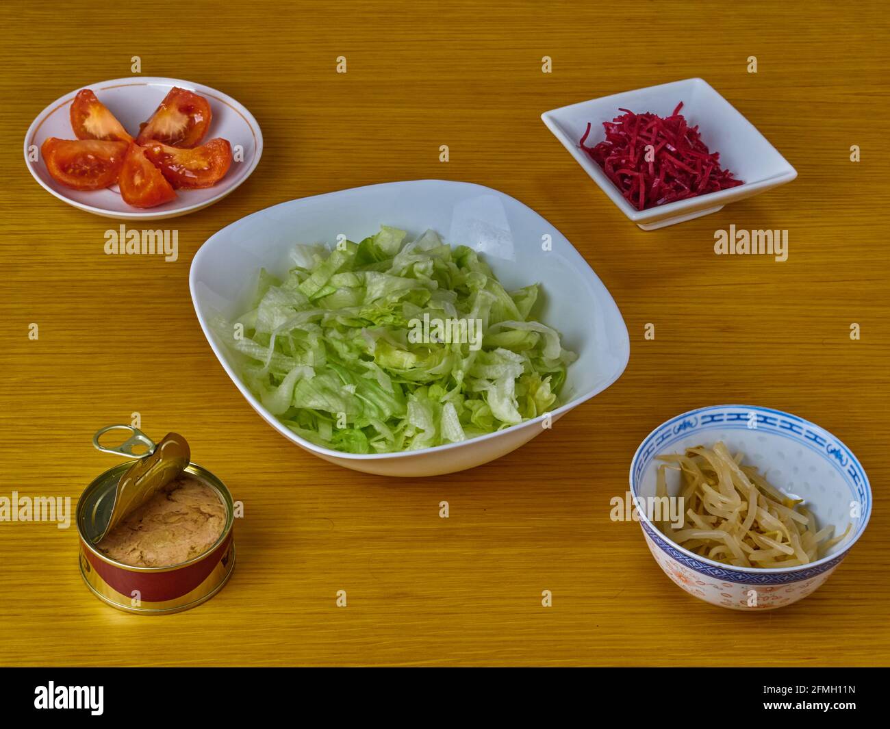 Ingredienti per la preparazione di tonno e insalata di vegan verde su sfondo di legno. Foto Stock