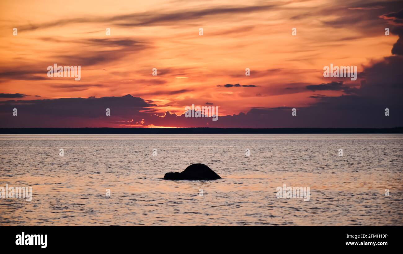 Tramonto luminoso sul Mar Baltico svedese dopo una pioggia tempo tardi una sera d'estate Foto Stock