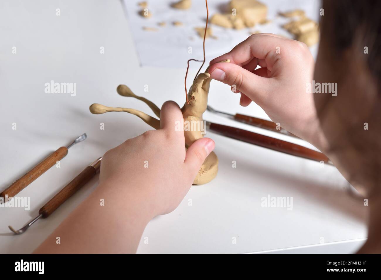Il bambino scolpisce una figura di plastilina Foto Stock