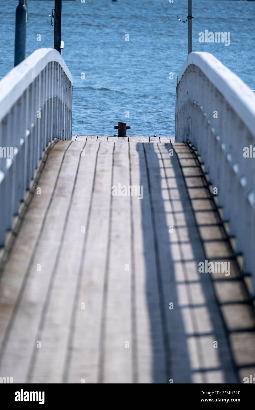 Helsinki / Finlandia - 9 MAGGIO 2021: Antico molo in legno con ringhiere in legno bianco contro il mare blu. Foto Stock