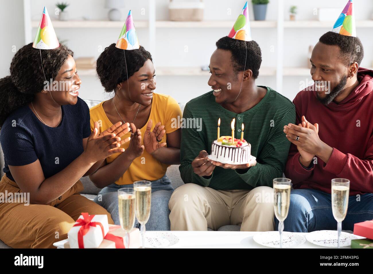 Gruppo di amici neri felici che festeggia il compleanno a casa Foto Stock