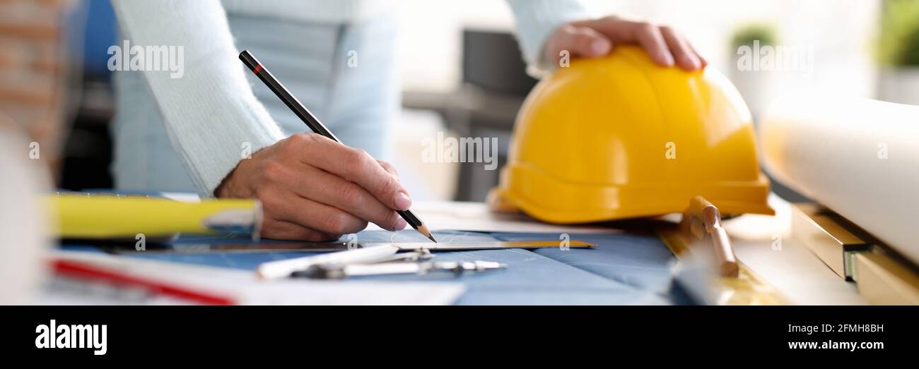 Donna architetto disegno con matita su closeup blueprint Foto Stock