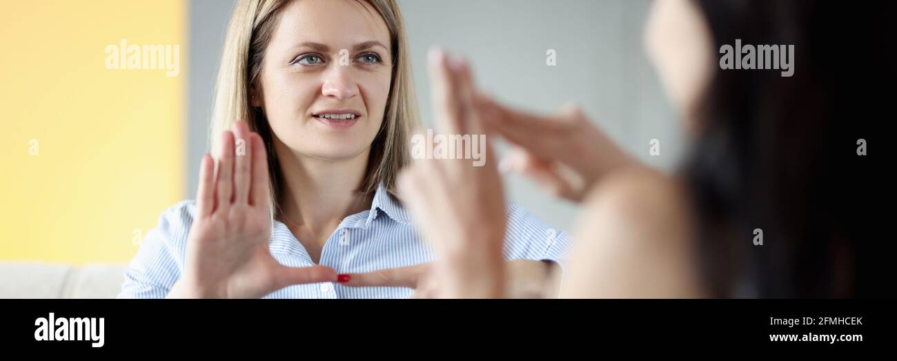 Due donne sordomute e mute che parlano gesti a casa Foto Stock