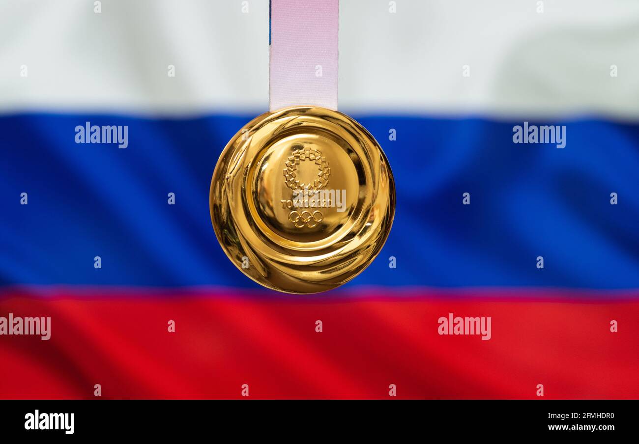 25 aprile 2021 Tokyo, Giappone. Medaglia d'oro dei XXXII Giochi Olimpici estivi 2020 a Tokyo sullo sfondo della bandiera della Russia. Foto Stock