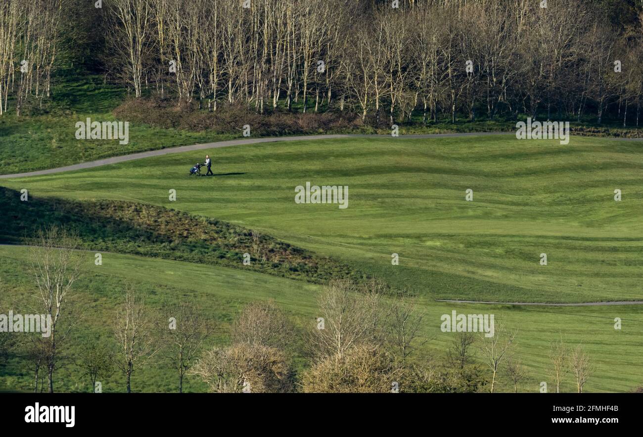 Un singolo golfista cammina attraverso un prato a strisce sul campo da golf dell'Hollins Hall Hotel a Baildon, Yorkshire, Inghilterra. Foto Stock