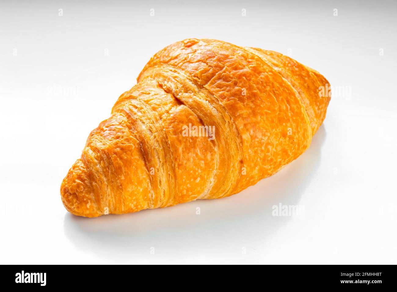 Vista frontale DI un croissant su sfondo bianco. Foto Stock
