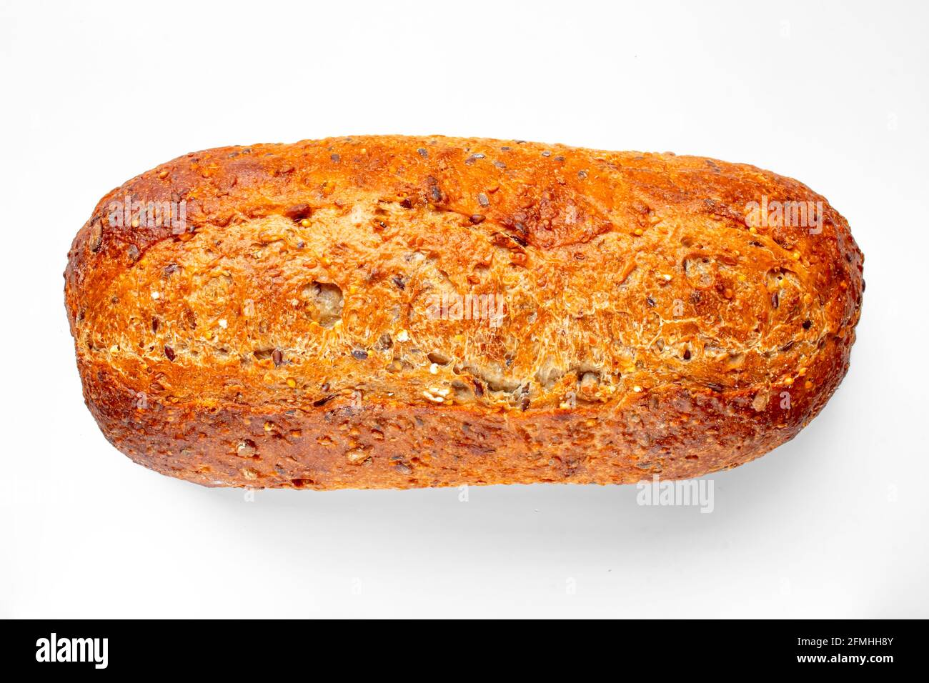 Vista dall'alto di un panino artigianale da forno e di un oval di grano da raccolta su un tavolo bianco. Foto Stock