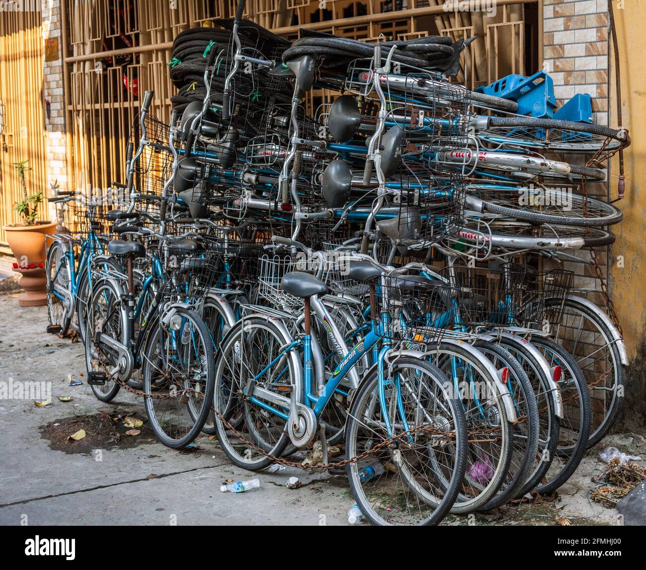 Biciclette vietnamite accatastate in alto nella strada posteriore di Hoi An, Vietnam Foto Stock