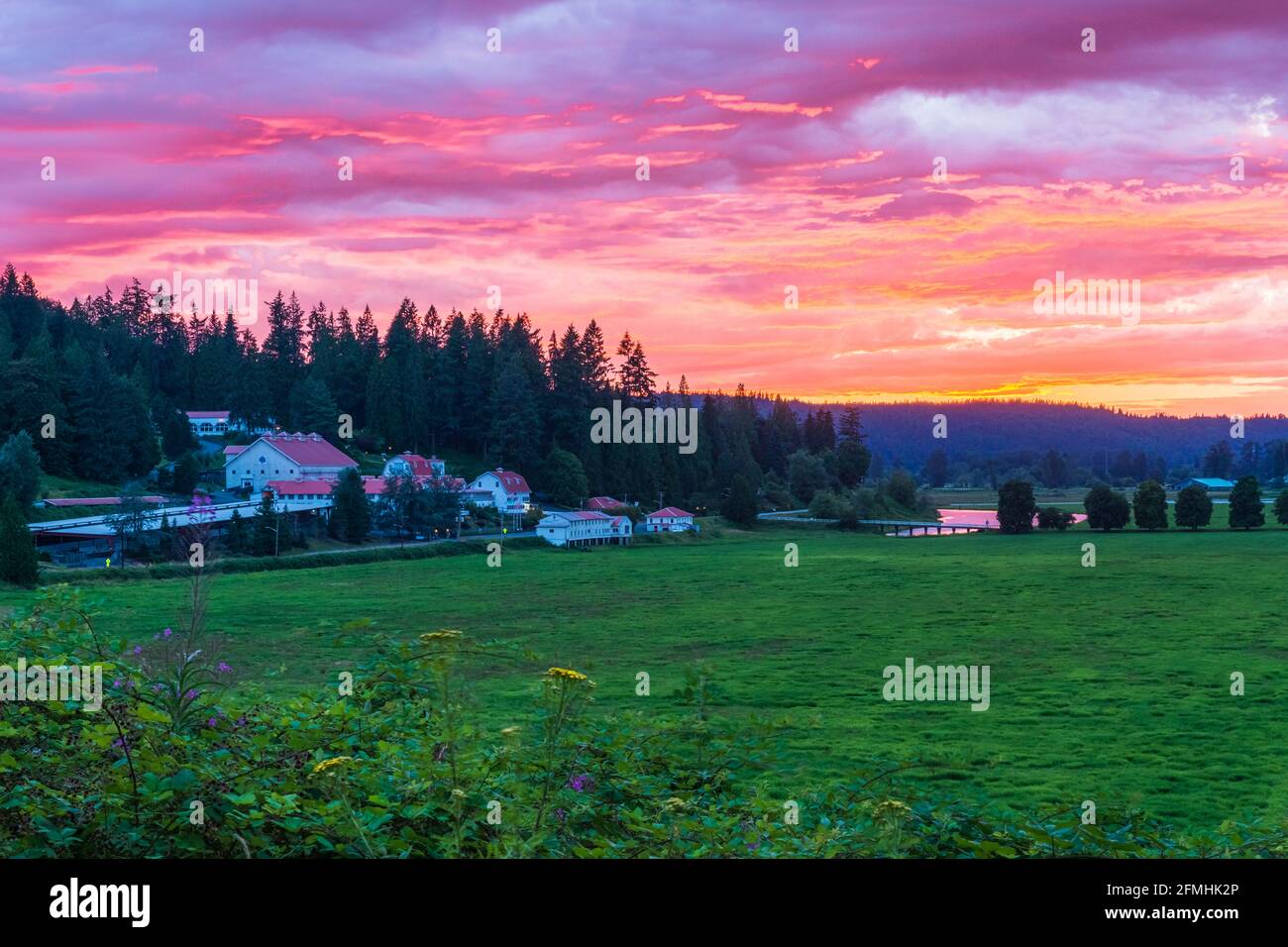 Carnation, WA, USA - 14 luglio 2016; un tramonto mozzafiato attraverso la Snoqualmie Valley e sopra le Carnation Farms Foto Stock