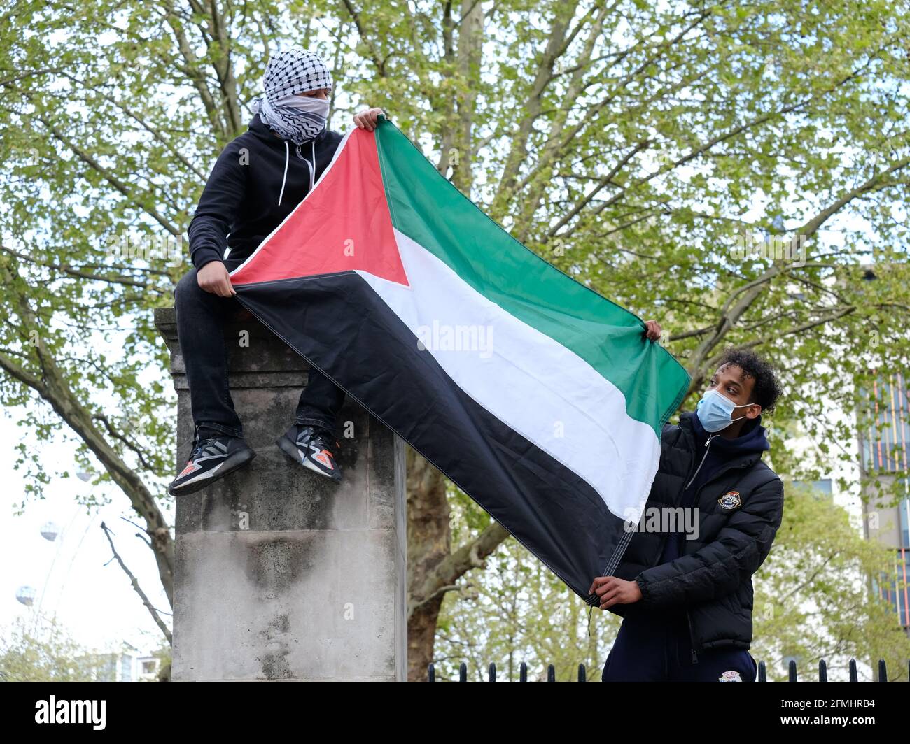 I manifestanti hanno indosso una bandiera palestinese in occasione di una manifestazione contro Sfratti pianificati a Sheikh Jerrah e la tempesta del Moschea di al-Aqsa Foto Stock