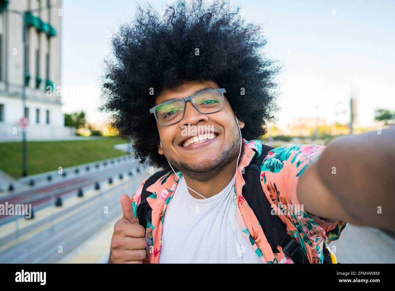 Uomo latino che prende un selfie all'aperto. Foto Stock