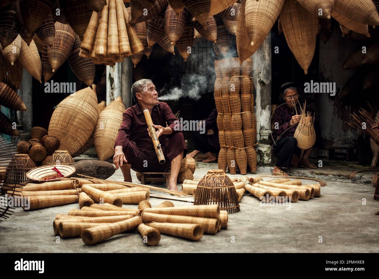 Artigiano che fa la trappola di pesce di bambù al vecchio villaggio, Hung Yen, Vietnam Foto Stock