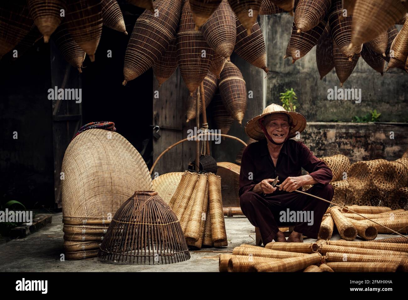 Artigiano che fa la trappola di pesce di bambù al vecchio villaggio, Hung Yen, Vietnam Foto Stock