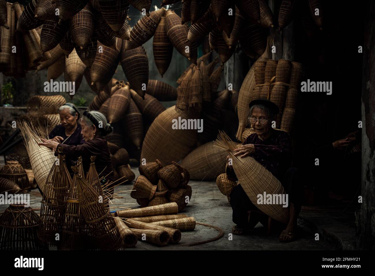Artigiano che fa la trappola di pesce di bambù al vecchio villaggio, Hung Yen, Vietnam Foto Stock