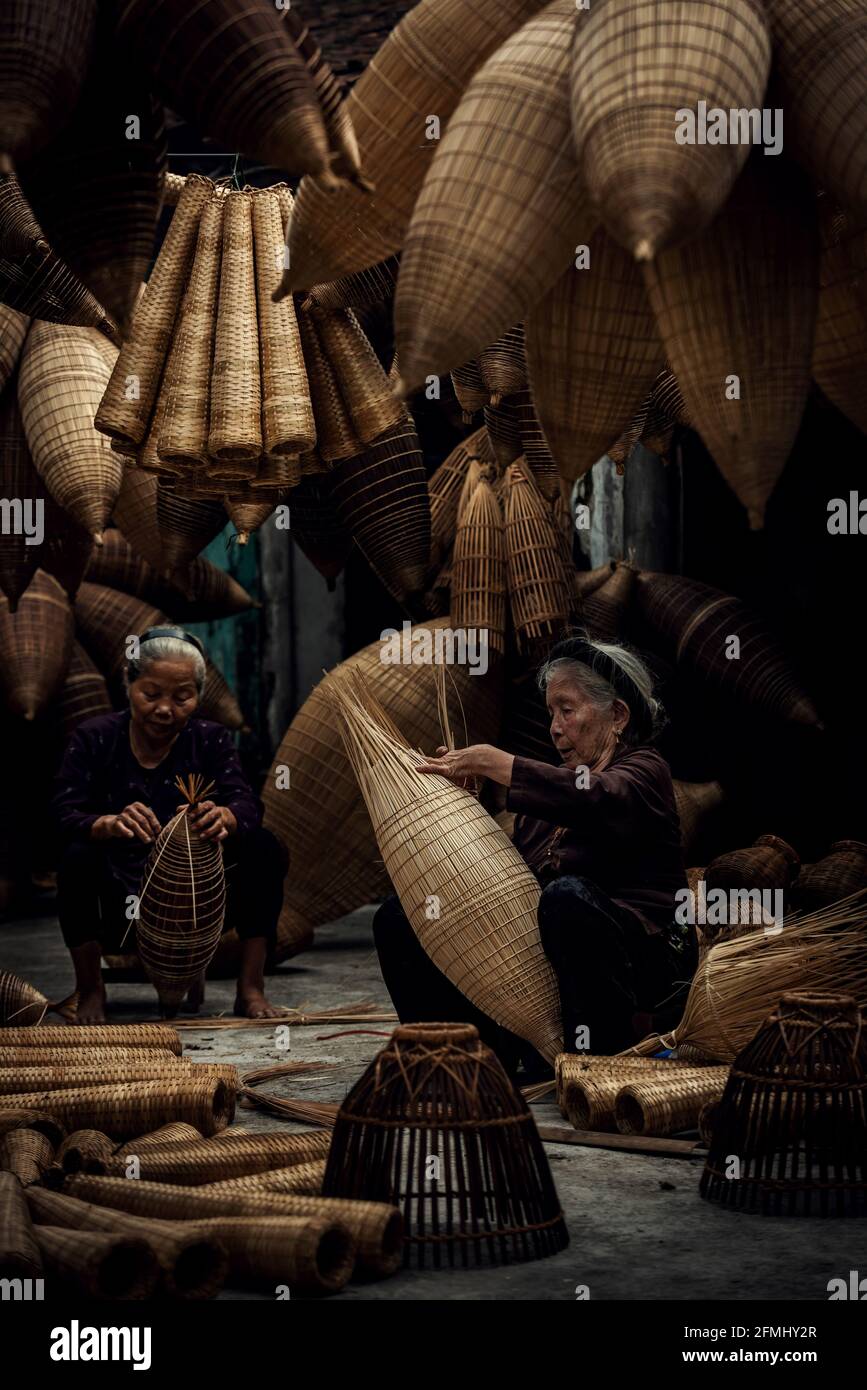 Artigiano che fa la trappola di pesce di bambù al vecchio villaggio, Hung Yen, Vietnam Foto Stock