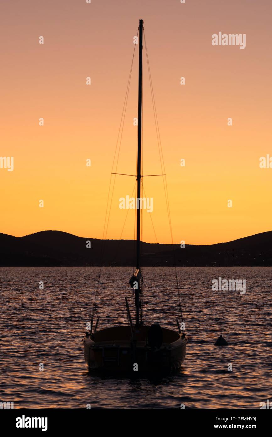 Vela barca silhouette al tramonto in mare Foto Stock