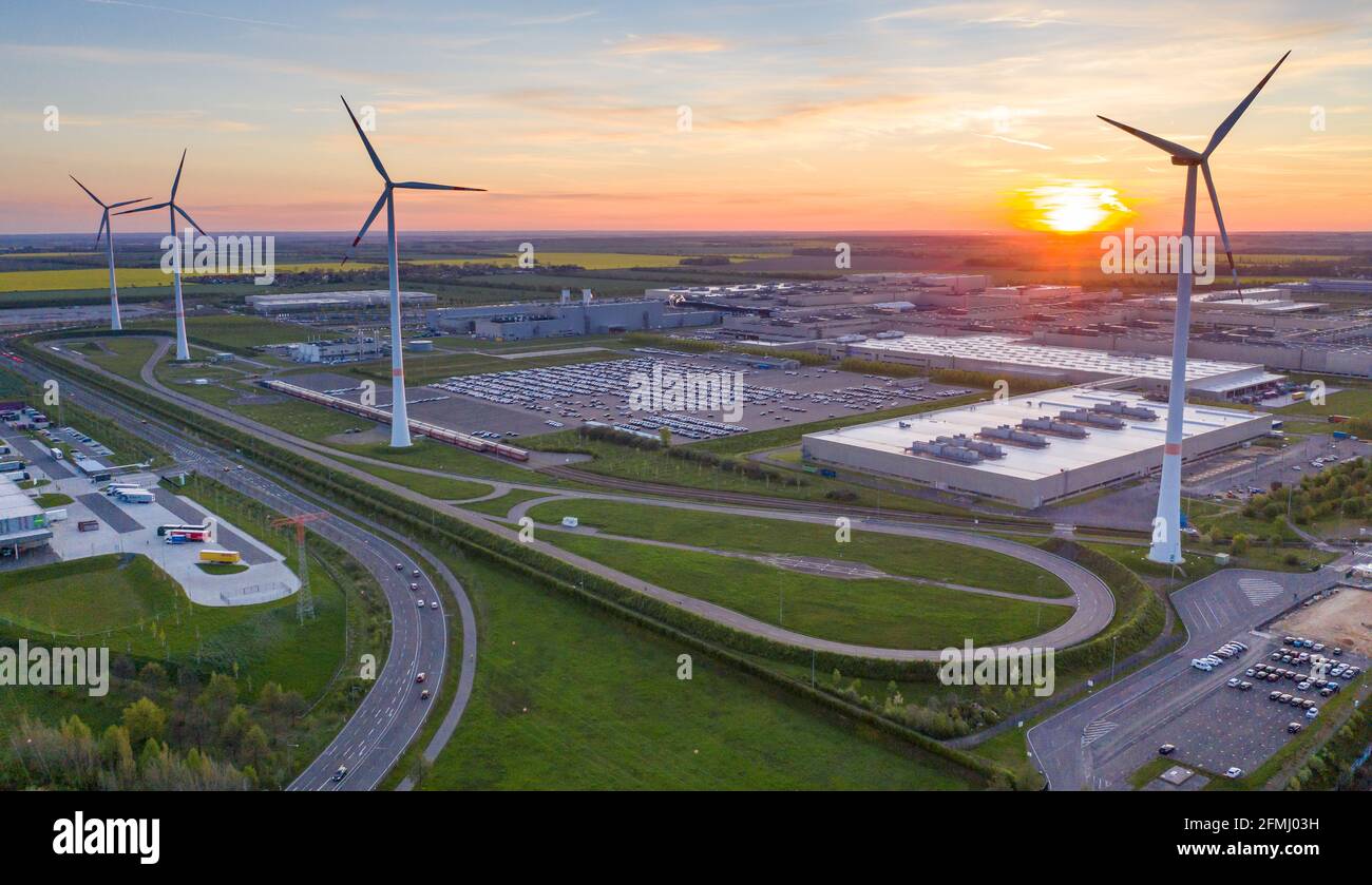 Lipsia, Germania. 10 maggio 2021. Il sole sorge dietro lo stabilimento BMW di Lipsia. Venerdì (07.05.), IG Metall aveva invitato i circa 5,500 dipendenti a partecipare a uno sciopero di avvertimento di 24 ore. L'IG Metall richiede aumenti salariali del quattro per cento e la riduzione della differenza di retribuzione e orario di lavoro tra Est e Ovest. Secondo il sindacato, circa 290,000 dipendenti nel distretto contrattuale collettivo di Berlino-Brandeburgo-Sassonia sono colpiti. (Foto aerea con drone) Credit: Jan Woitas/dpa-Zentralbild/dpa/Alamy Live News Foto Stock