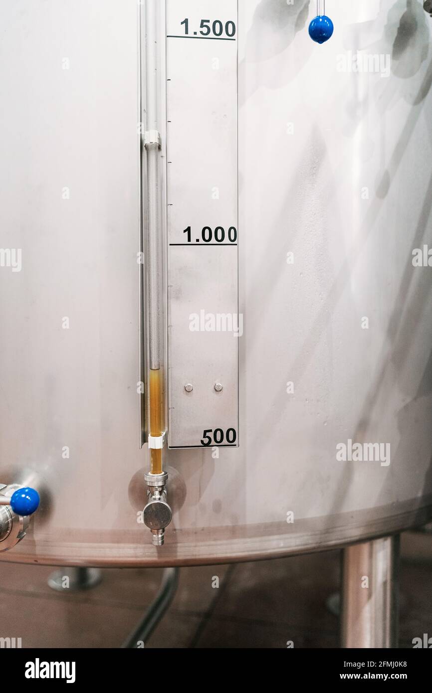 Serbatoio in acciaio inox con densimetro con numeri e scala liquido nel tubo nella fabbrica di birra Foto Stock