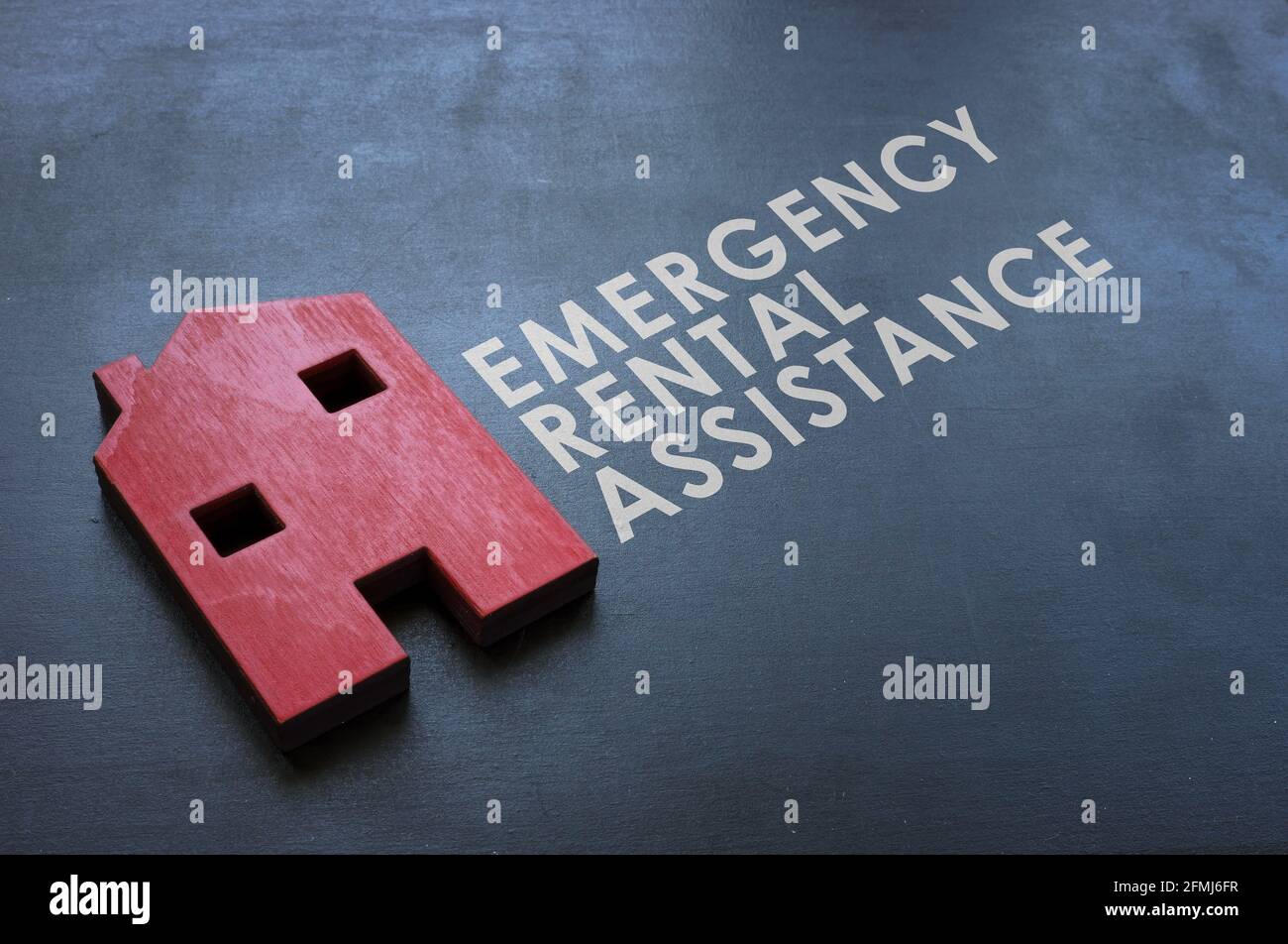 Programma di assistenza a noleggio di emergenza ERAP. Casa di legno rosso sulla lavagna. Foto Stock