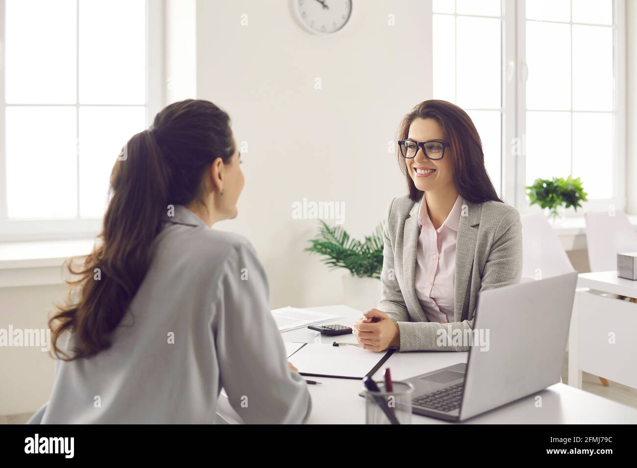 La manager femminile fornisce consulenza al cliente e la informa sui termini del prestito. Foto Stock