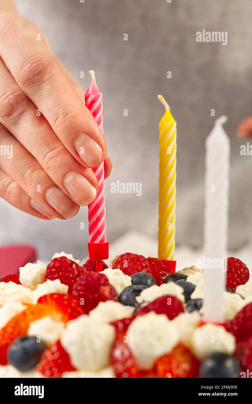 Mano femminile aggiungere candele di compleanno a torta di fragole fatte in  casa. Torta di fragole e candele di compleanno Foto stock - Alamy