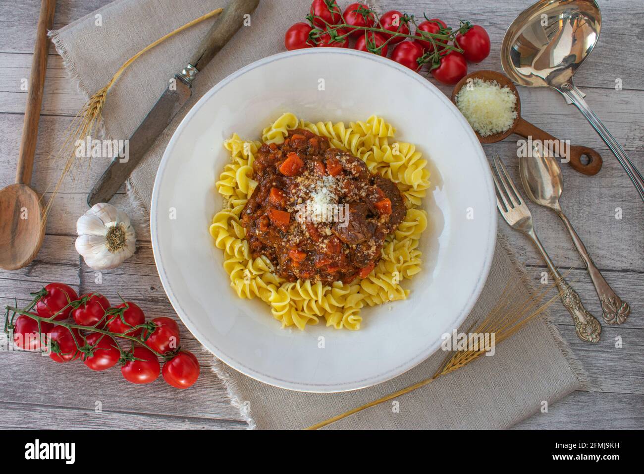 Ragù di manzo italiano con pasta su un piatto bianco tavolo rustico in legno Foto Stock