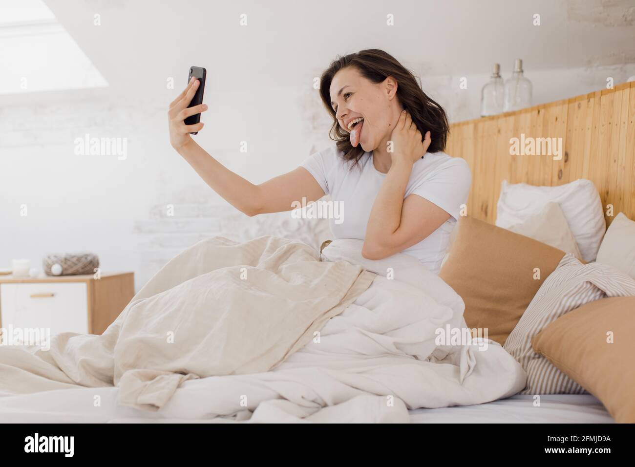 giovane donna attraente prende un selfie appena dopo il risveglio Foto Stock