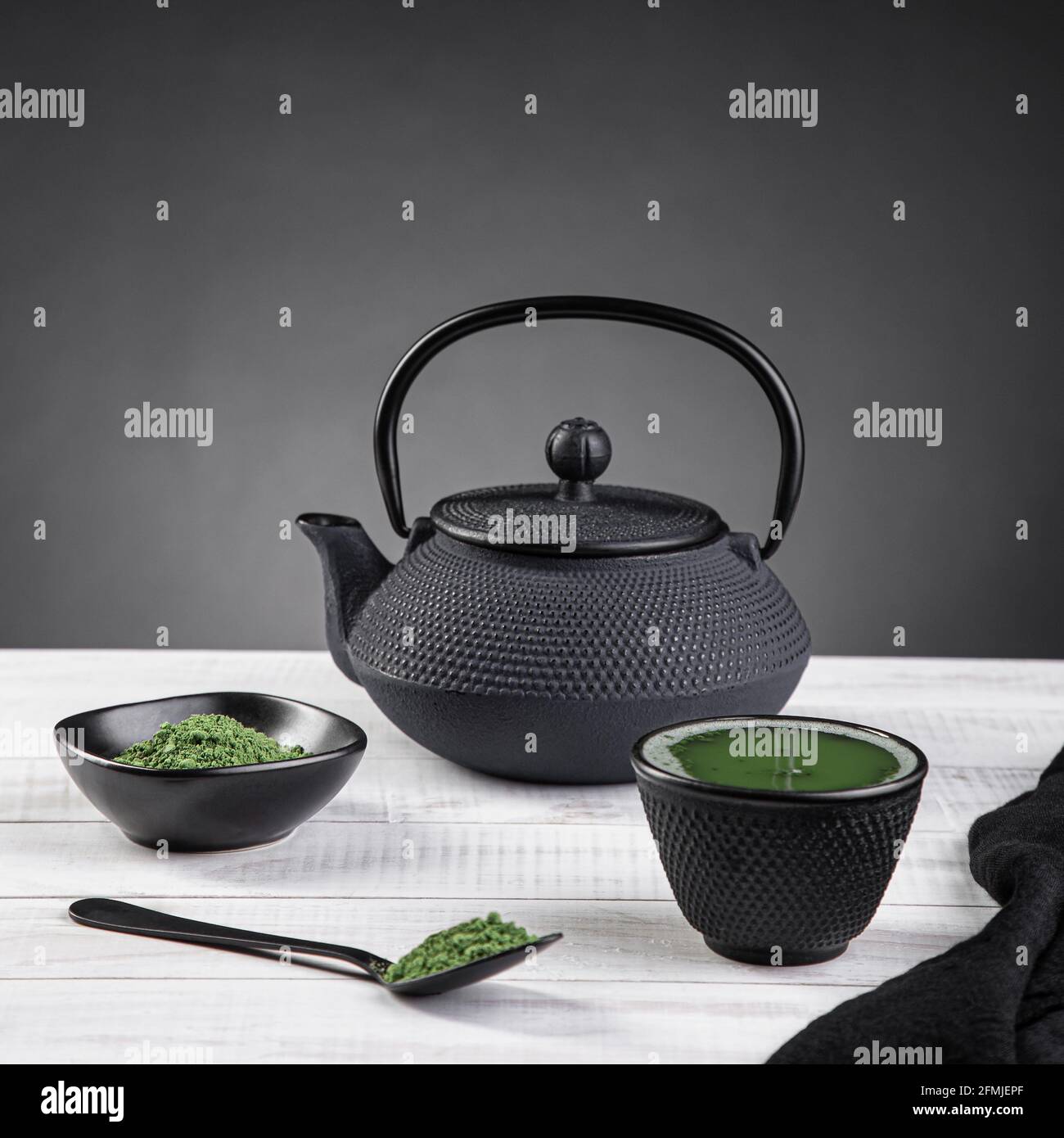Polvere da tè Matcha e accessori da tè su base leggera su sfondo grigio con copyspace. Cerimonia del tè. Bevanda tradizionale giapponese Foto Stock