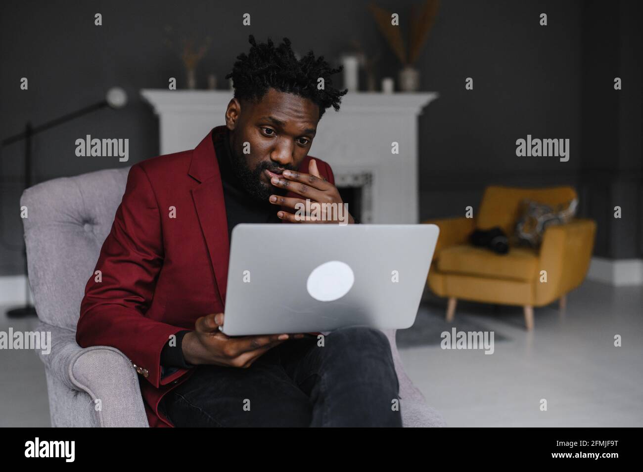 Black Man Working from Home con videoconferenza di gruppo online attivata Computer portatile Foto Stock