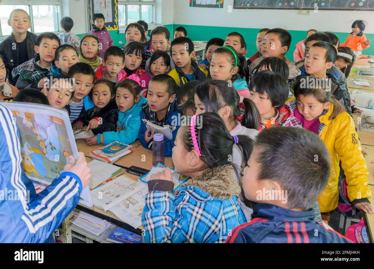 Gli studenti della scuola elementare Lixiana nelle zone rurali di Hebei, in Cina, hanno letto a voce alta la storia di Natale. Foto Stock