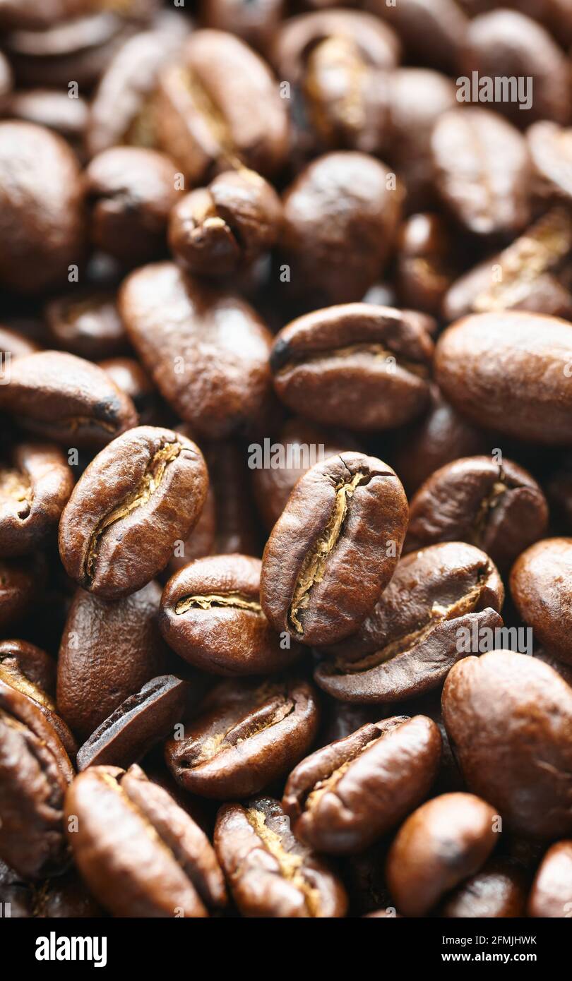 Primo piano immagine di chicchi di caffè appena tostati scuri, messa a fuoco selettiva. Foto Stock