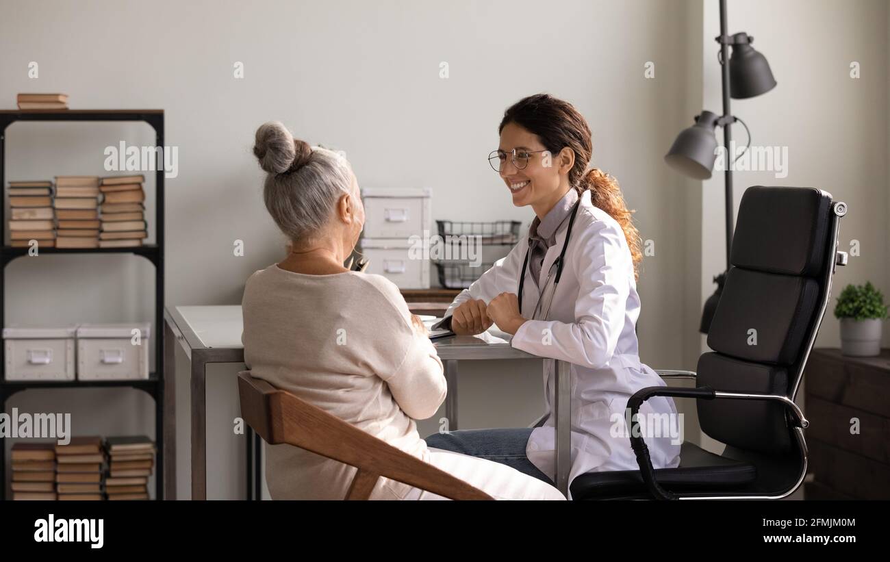 Felice donna medica informare la paziente anziana di dinamica positiva Foto Stock