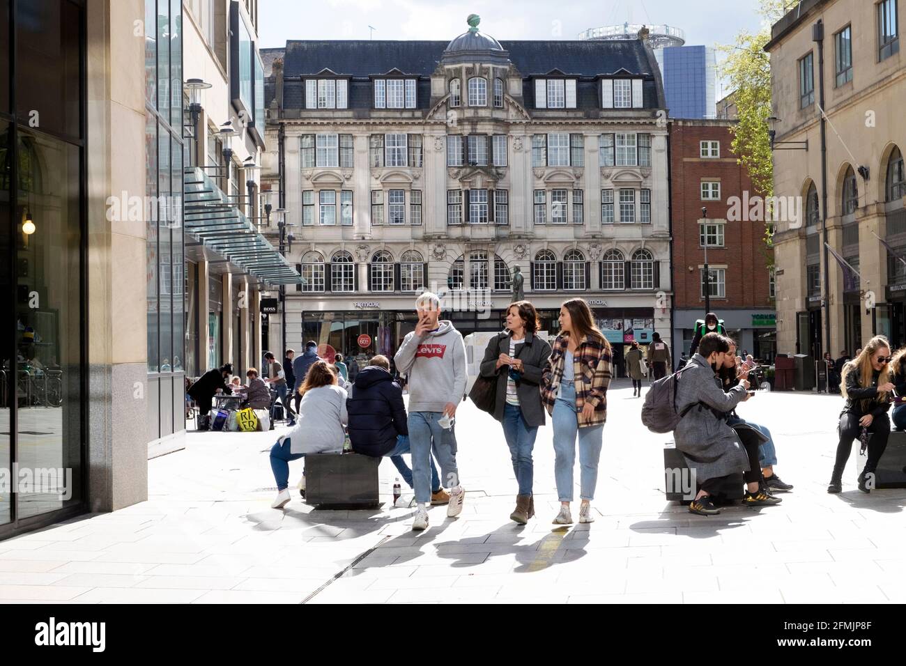 La gente che acquista camminare rilassandosi seduto in una giornata di sole dentro Primavera sulla strada pedonale fuori dai negozi nel centro di Cardiff Maggio 2021 KATHY DEWITT Foto Stock