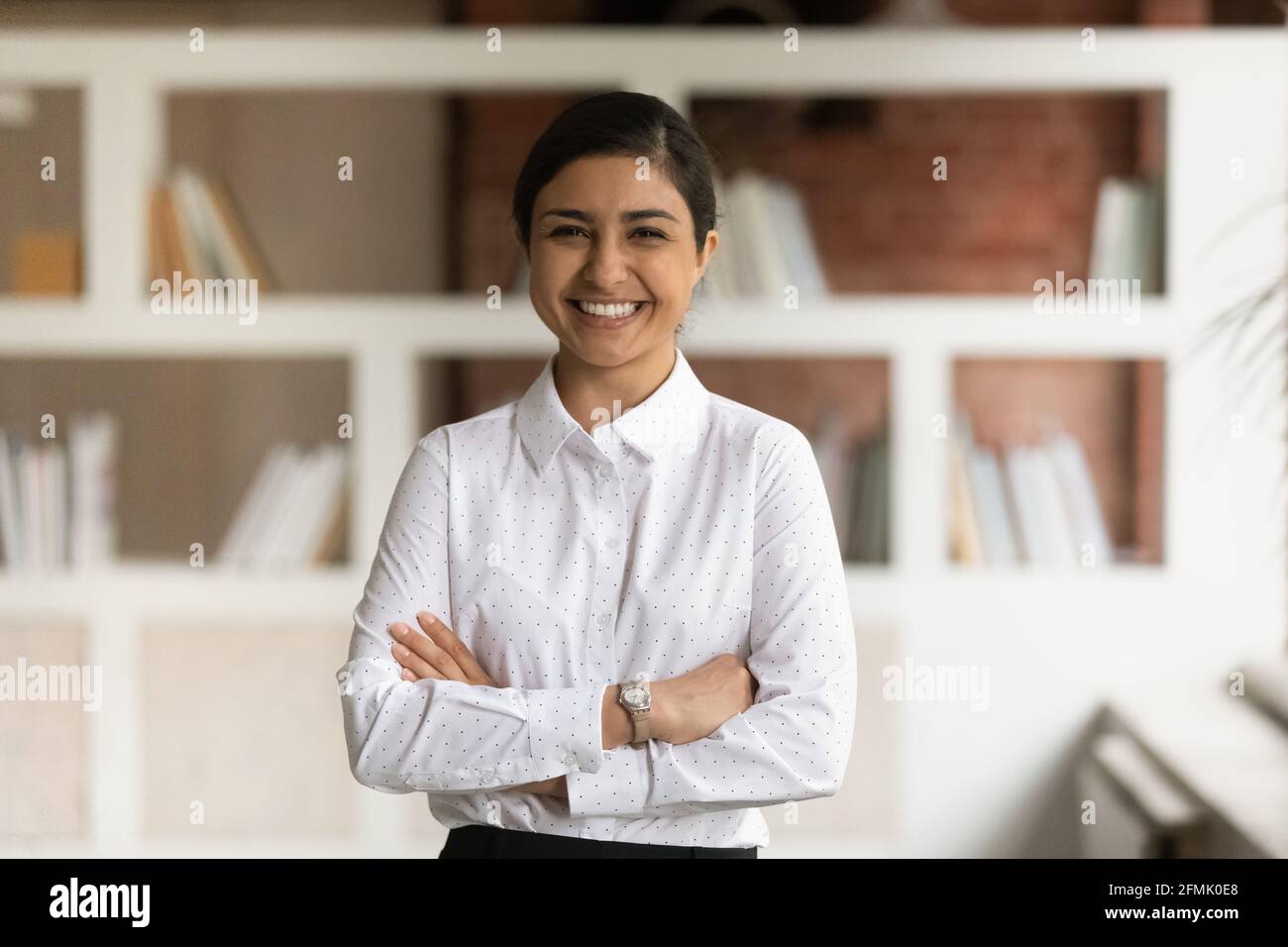 Testa ritratto girato sorridente imprenditore indiano con le braccia incrociate Foto Stock
