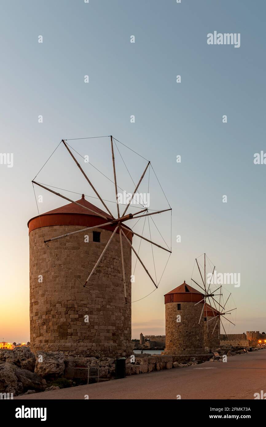 I mulini a vento vicino alla città vecchia di Rodi porto mandraki all'alba. Foto Stock