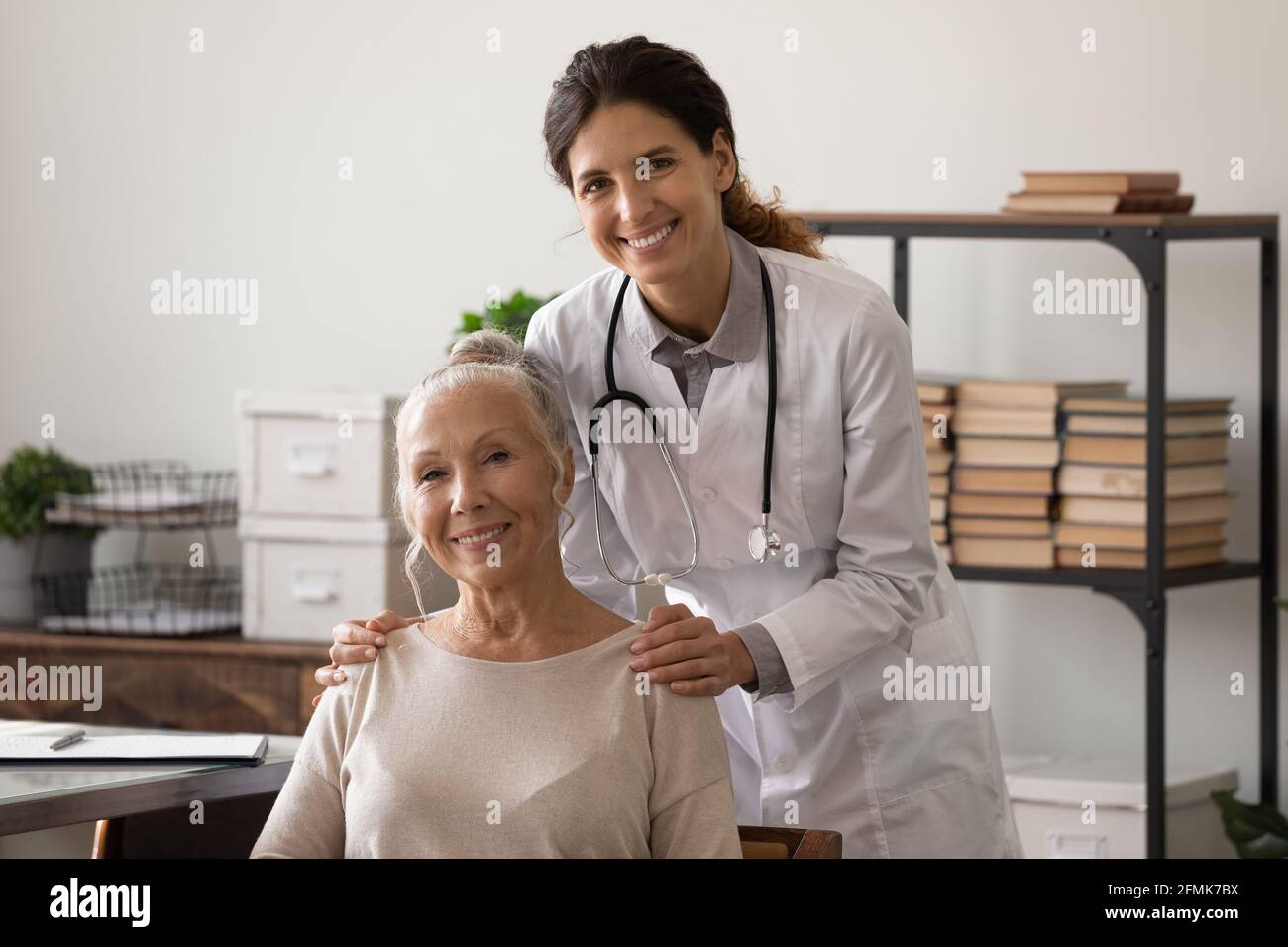 Ritratto di medico e paziente anziano guardando la fotocamera Foto Stock