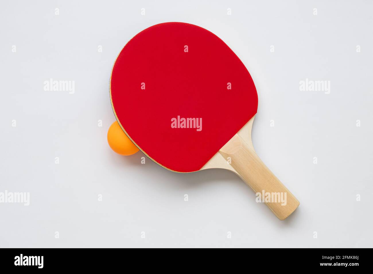 Racchetta da ping pong su sfondo bianco, con palla da ping pong arancione. Foto Stock