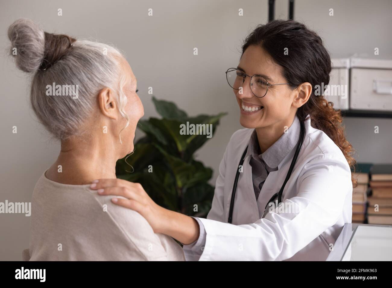 Dottore femminile incoraggiare donna anziana malsana a appuntamento in ospedale Foto Stock