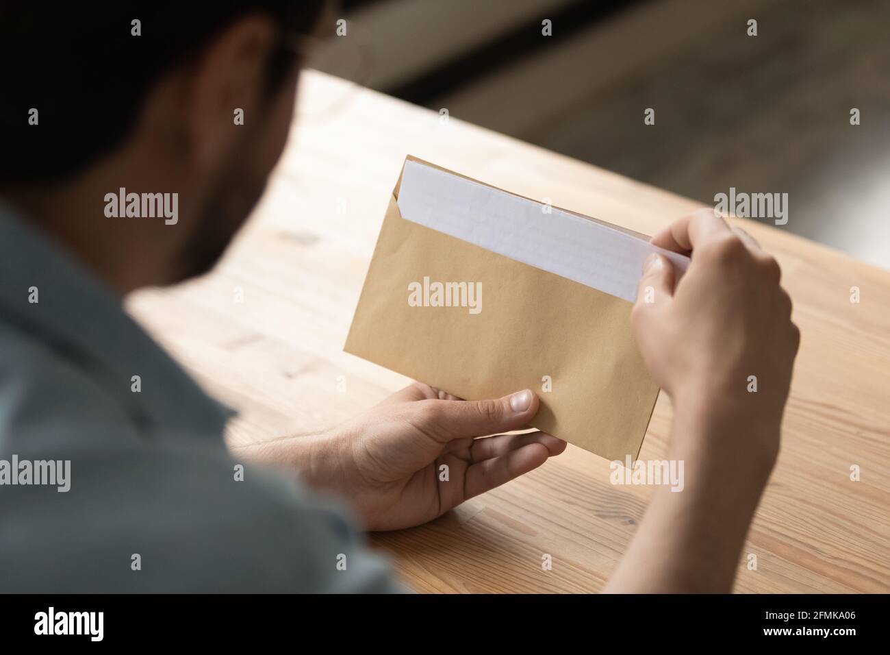 Primo piano businessman apertura busta con lettera, lavorando con corrispondenza Foto Stock