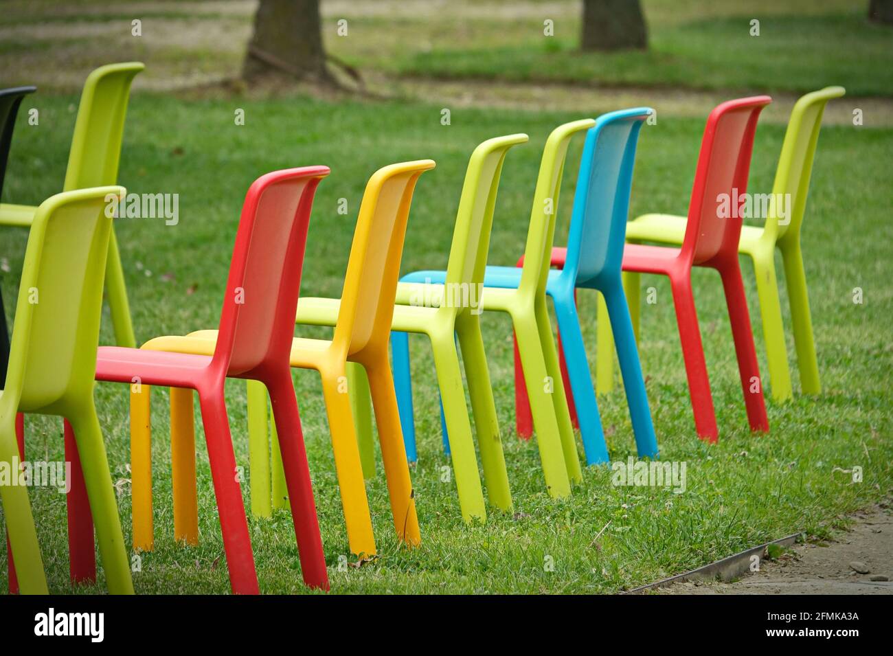 Fila di sedie vuote multicolore per un evento all'aperto Foto Stock