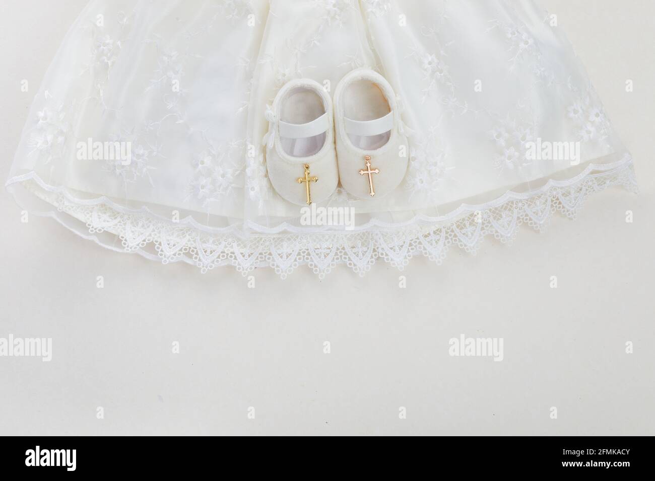 Battesimo sfondo con battesimo bambino vestito, scarpe, e croce su sfondo  pastello Foto stock - Alamy