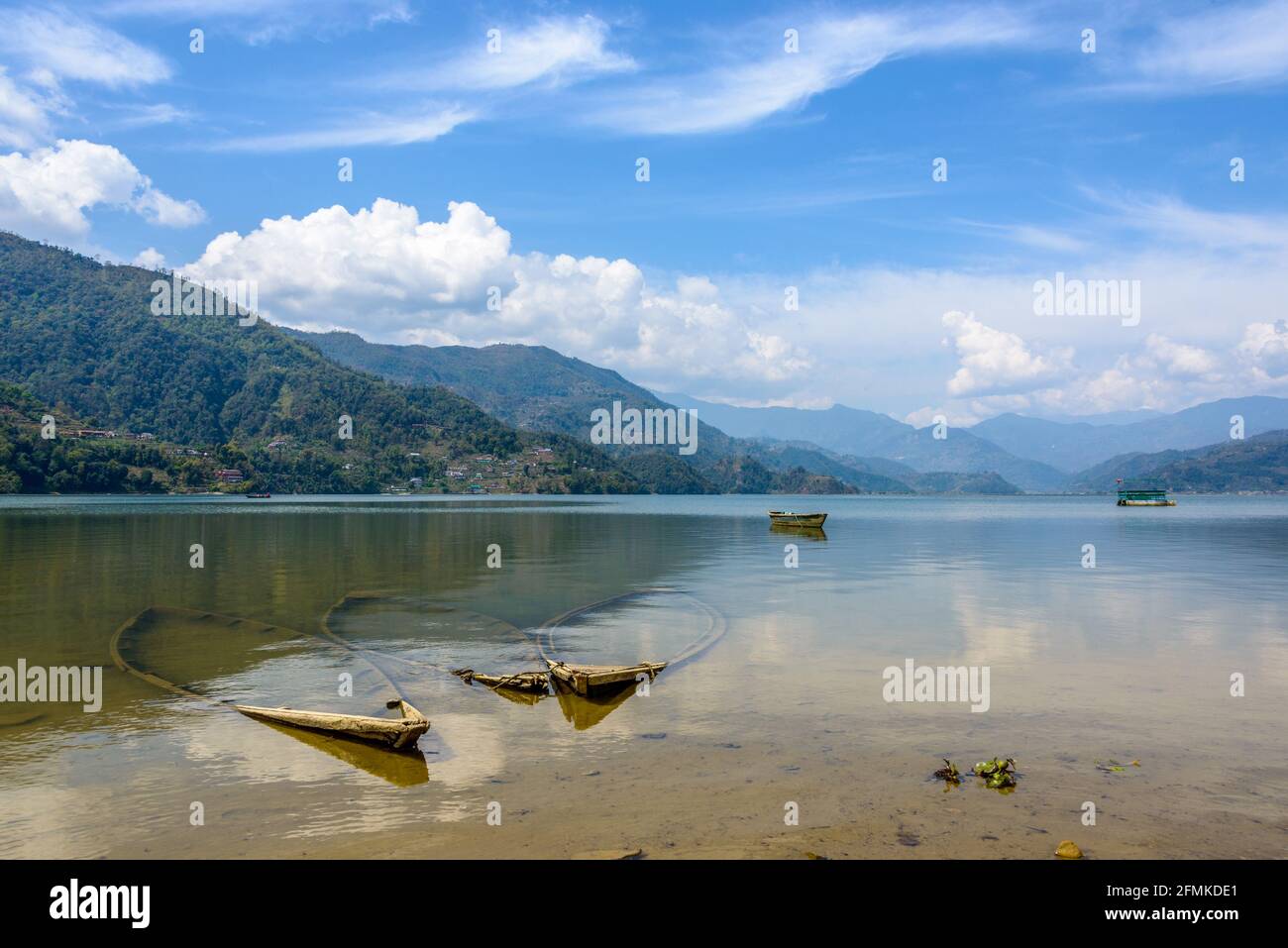 Tre barche affondate nel lago di Phewa, Pokhara, Nepal Foto Stock