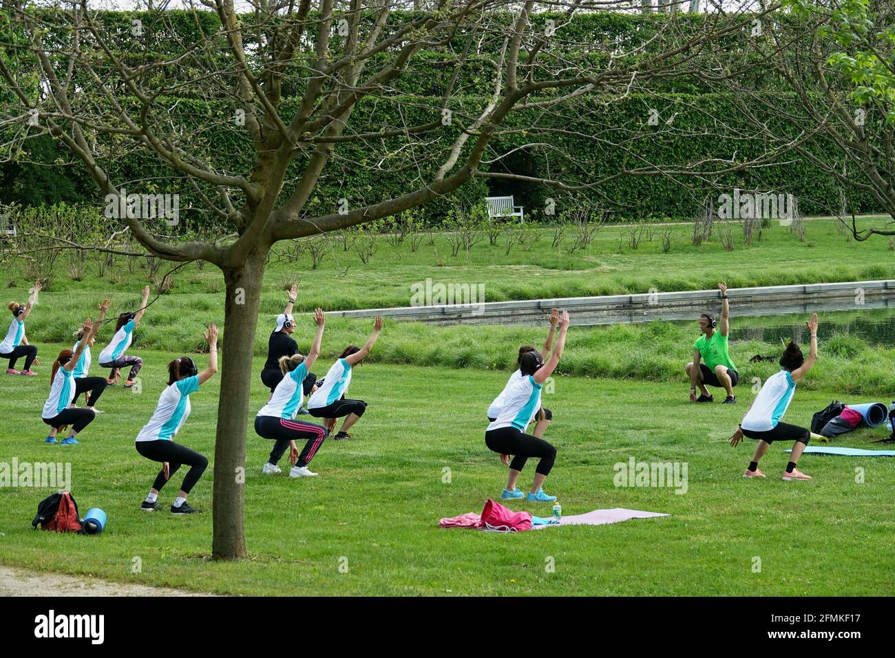 Allenamento all'aperto. Aria aperta. Le persone che fanno esercizio di gruppo nel parco mantenendo la distanza l'una dall'altra. Distanza sociale dopo covid-19 coronavirus qu Foto Stock
