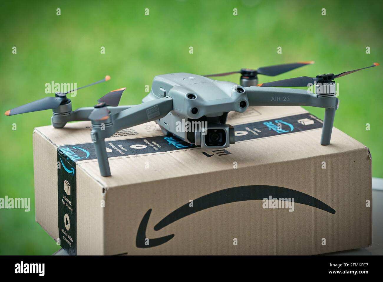 Focus selettivo sul drone che consegna il pacco con il logo amazon su cartone. Milano, Italia - Maggio 2021 Foto Stock