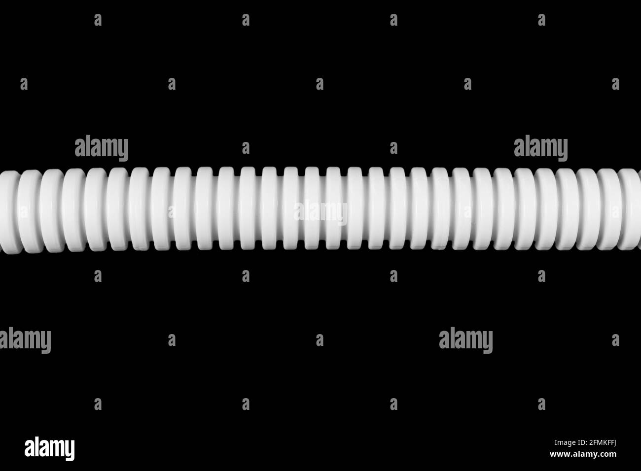 Tubo corrugato in plastica per installazione elettrica da vicino. Tubo corrugato isolato su fondo nero. Foto Stock