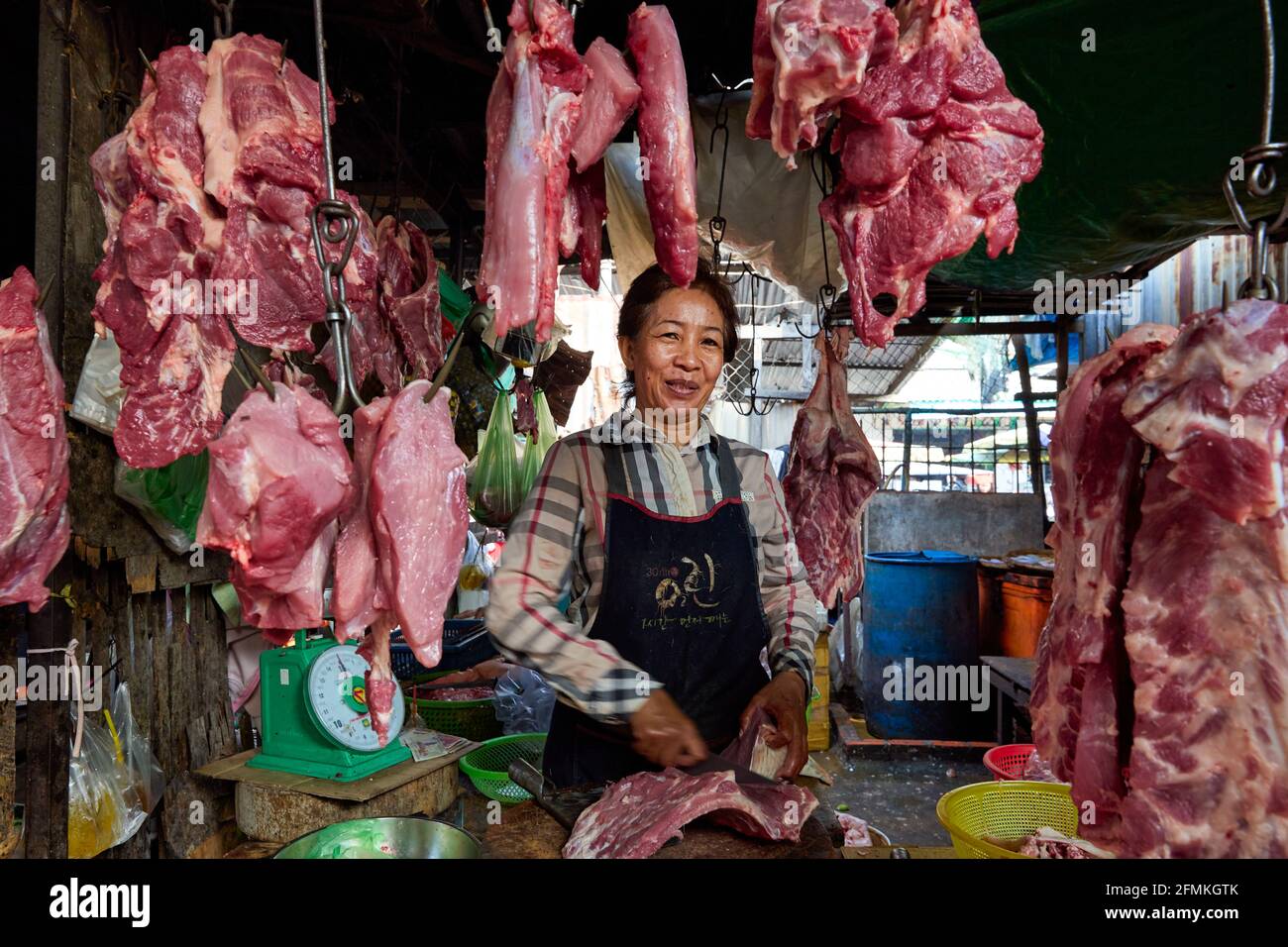 Macellaio all'interno del mercato russo (Psah Toul Tompoung) a Phnom Penh, Cambogia Foto Stock