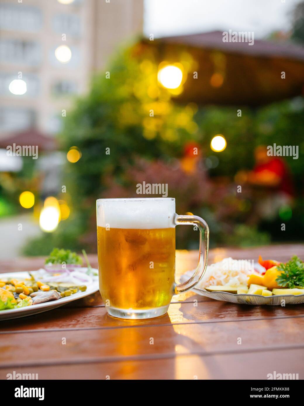 Tazza di birra sul tavolo servito nella caffetteria in terrazza Foto Stock